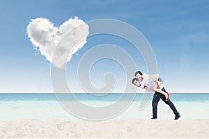 Boyfriend giving piggyback ride under heart cloud