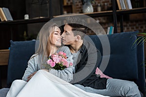 boyfriend going to kiss girlfriend with bouquet of roses international womens