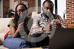 Boyfriend ignoring upset girlfriend after arguement spending time on smartphones