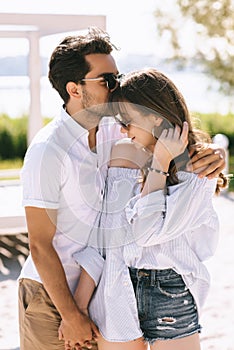 boyfriend kissing girlfriend forehead at city
