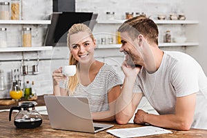 boyfriend looking at girlfriend with cup of coffee photo