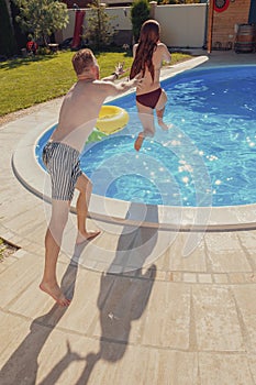 Boyfriend pushing girlfriend into the swimming pool