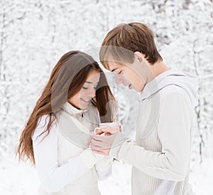 Boyfriend warms hands sweetheart, frozen in the cold photo