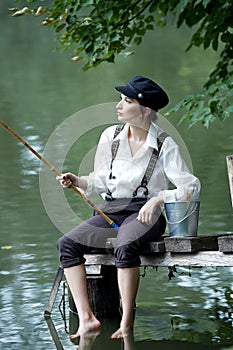 Boyish looking girl fishing outdoors