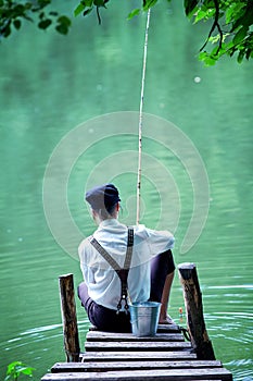 Boyish looking girl fishing outdoors photo
