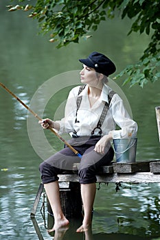 Boyish looking girl fishing outdoors photo