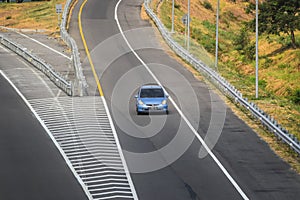 Blue color Honda jazz or Honda fit driving fast on trans jawa highway blurry in motion