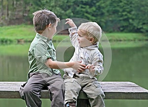 Boys on a bench at the pond
