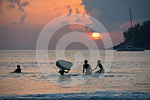 Boys on boards in sunset