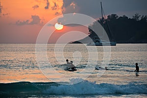 Boys on boards in sunset