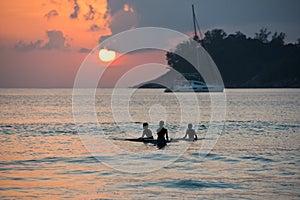 Boys on boards in sunset