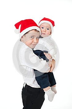 Boys brothers in santa's hats hugging