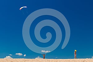 Boys with colorful kite against blue sky at the beach