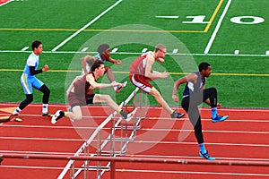 Boys competing in hurdles at a Track Competition