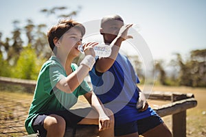 Boys drinking water after workout during obstacle course