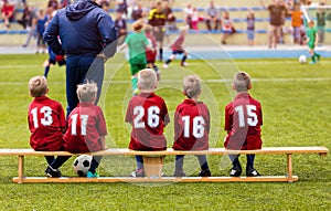 Boys Football Team Sitting on Substitution Bench. Kids School Soccer Tournament Match