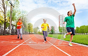 Boys and girl in colorful uniforms run marathon