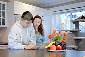 boys girl in the kitchen looking for food delivery in phone quiet life brother and sister without parents eat fast food