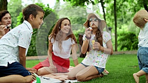 Boys and girl playing in forest. Laughing parents relaxing with children in park