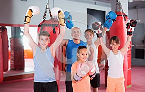 Boys and girl posing with coach in fighting stance