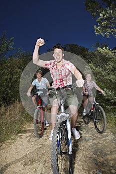 Boys And Girl Riding Bicycles On Country Road