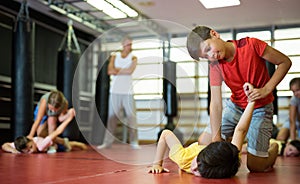 Boys and girls in gym exercising armlock move