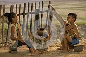 Boys and girls playing folk music with local instruments. Rural children playing with blowing music and laughter. People Thailand