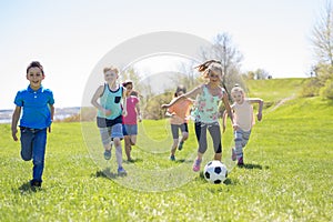 Boys and girls running towards football