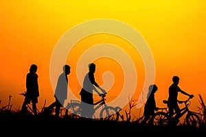 Boys and girls standing a bike with sunset Silhouette concept