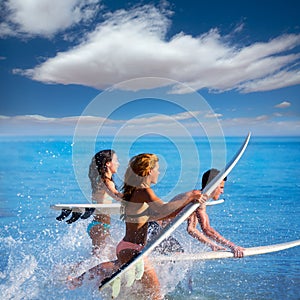 Boys and girls teen surfers running jumping on surfboards