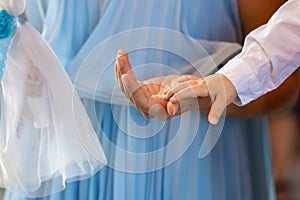 Boys hand on his mothers hand in church. Children baptism christenings photo