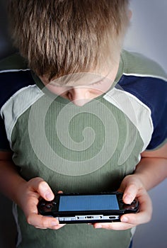 Boys hand playing portable video game