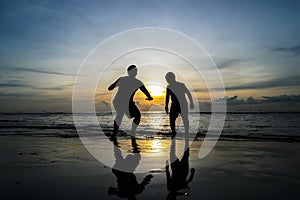 Boys jumping on the beach Sunset