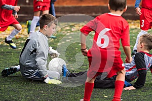 Boys kicking soccer ball at sports field