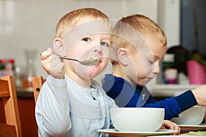 Boys kids children eating corn flakes breakfast meal at the table