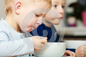 Boys kids children eating corn flakes breakfast meal at the table