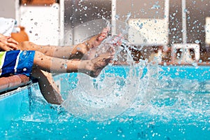 Boys legs splashing water in pool photo