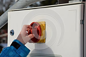 Boys like to turn on switches and push buttons. holding a red button and getting ready to start an electrical device. hand fingers