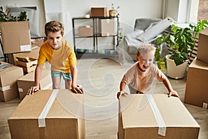 Boys Moving Boxes in New House