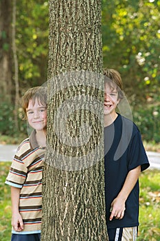 Boys Peeking Around a Tree