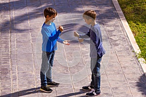 Boys play game rock paper scissor on sunny day in the yard