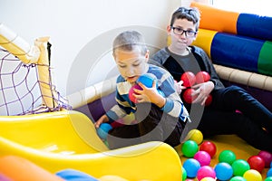 Boys play in pool with soft plastic balls