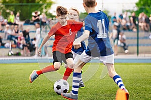 Boys play soccer game. Junior competition between players running and kicking soccer ball