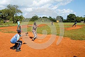 Boys playing baseball on a field at Las Galeras