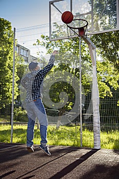 Boys playing basketball outdoors on a sports field