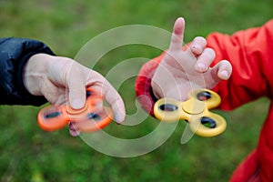 Boys playing fidget spinners. Outdoor