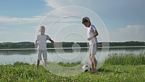 Boys playing football on the beach at the day time. Concept of friendly family.