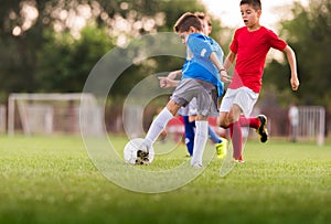 Boys playing football soccer game on sports field