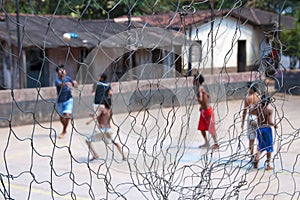 Boys playing soccer barefoot