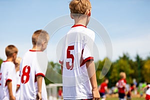 Boys playing soccer football match on football field. Kids kicking ball